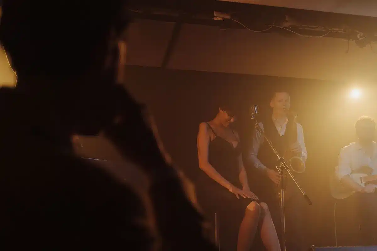 Sänger und Band auf der Bühne mit warmer Beleuchtung und dezenter Zeltspitzen-Inszenierung