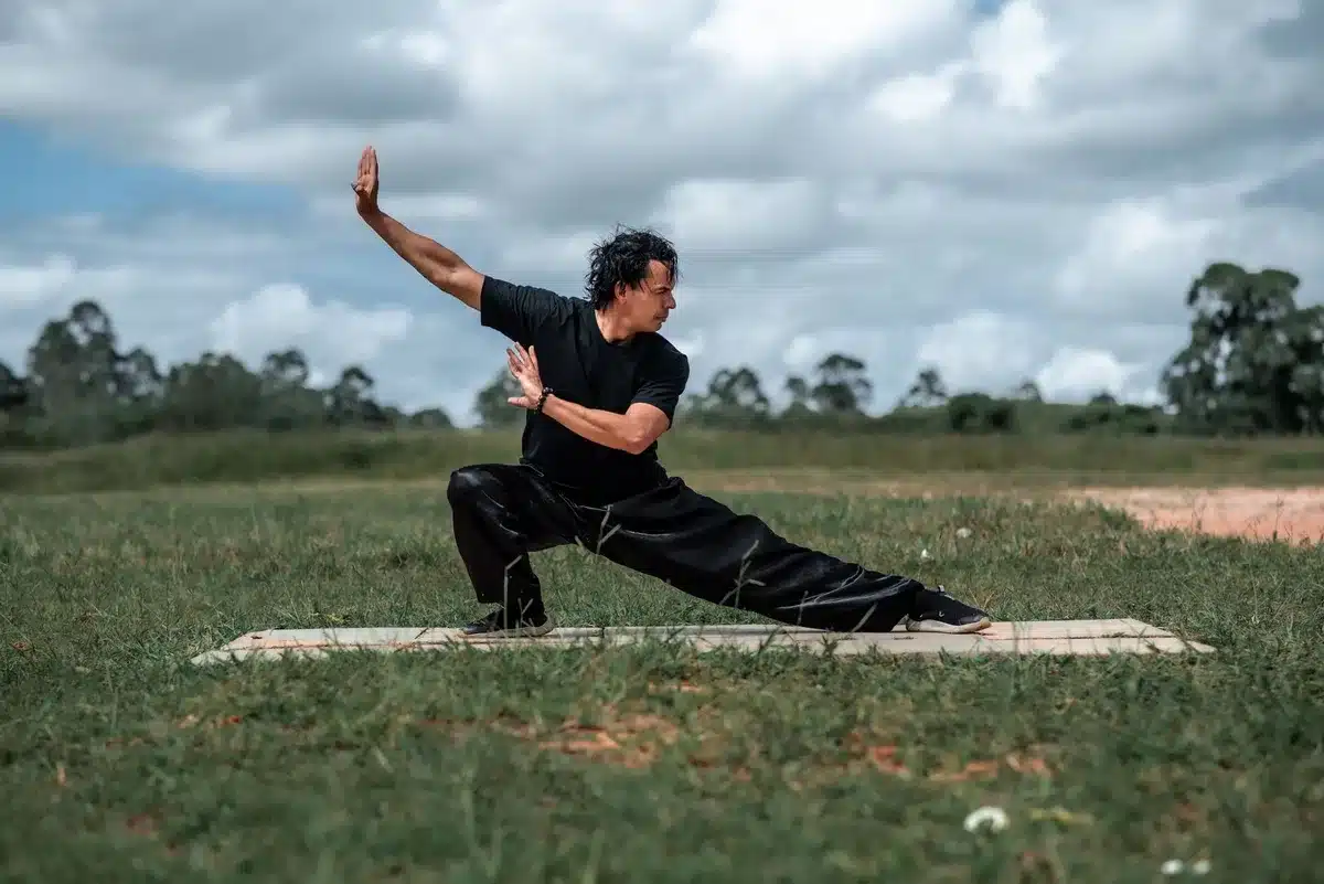 Person beim Taijiquan in ruhiger Parkumgebung mit fließenden Bewegungen