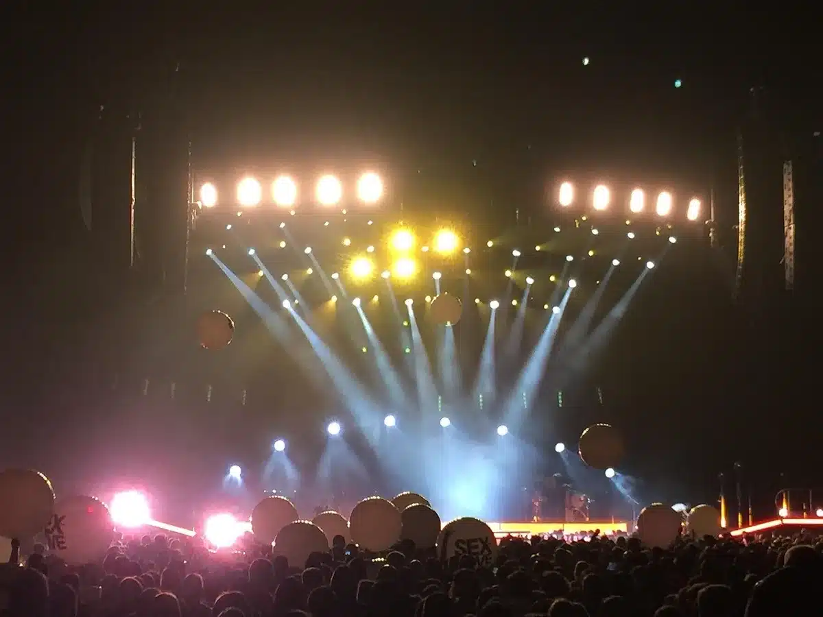 Anonyme Menschenmenge auf einem Festival bei Nacht mit Bühnenlicht