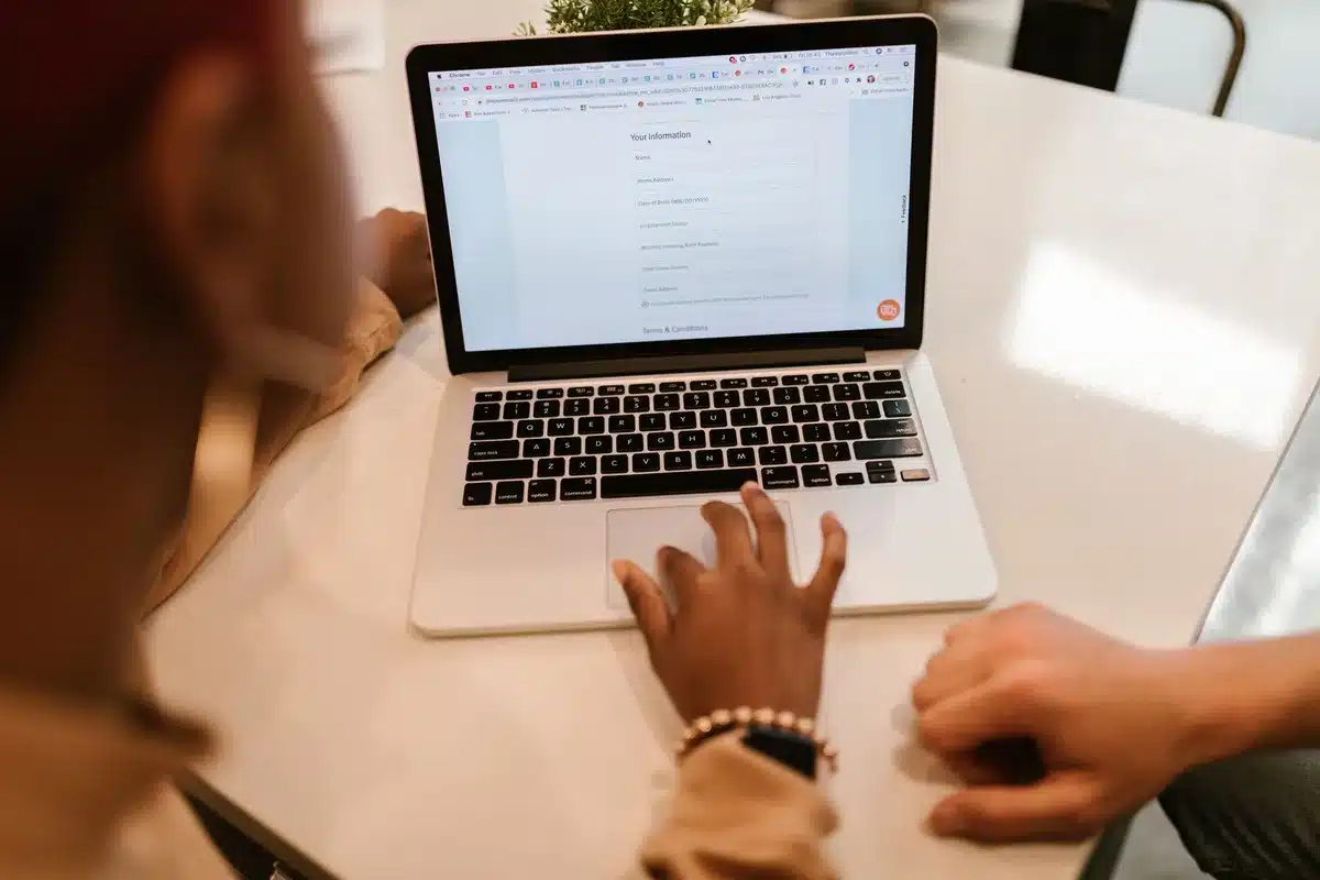 Junge Person füllt Bewerbungsformular am Laptop aus