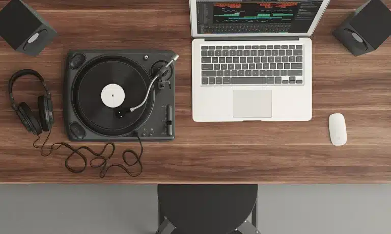 Plattenspielerarm und Hände über einer Sammlung von Vinylhüllen