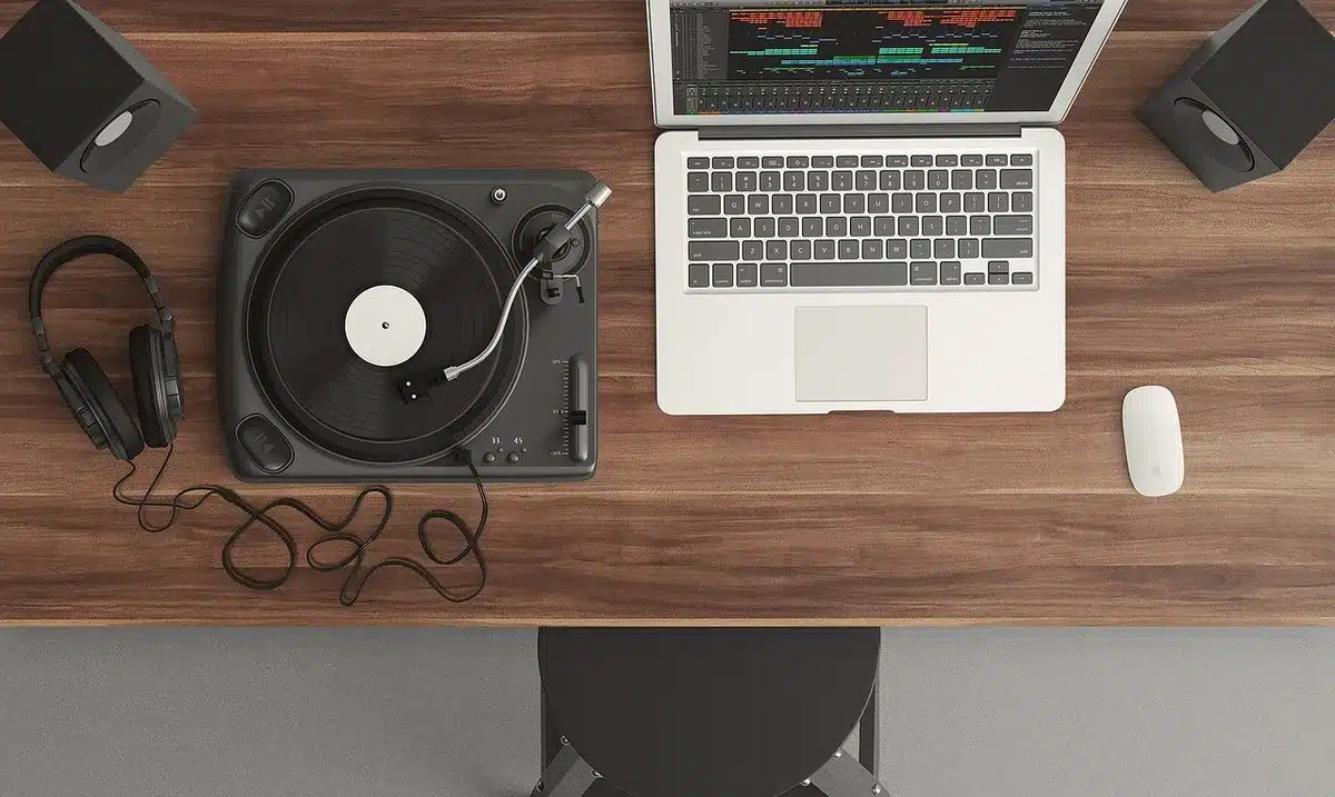 Plattenspielerarm und Hände über einer Sammlung von Vinylhüllen