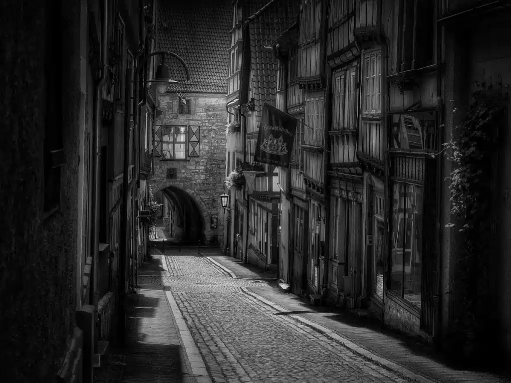 Blick in eine Gasse der Lübecker Altstadt mit Holstentor im Dunst