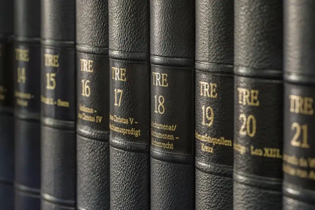 Zwei anonyme Hände übergeben alte ledergebundene Bücher in einem Archivraum