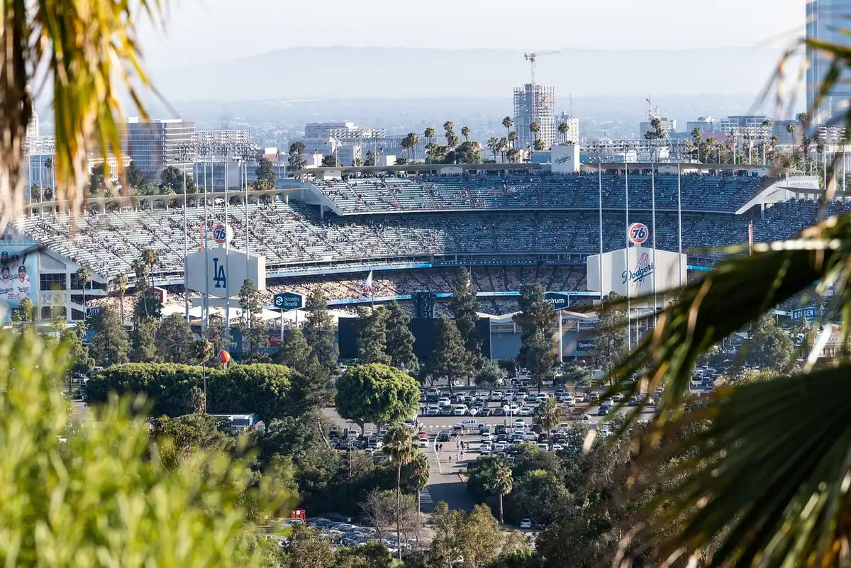 Silhouettierte Fans vor einem Stadion mit Smartphones und Tickets in der Hand