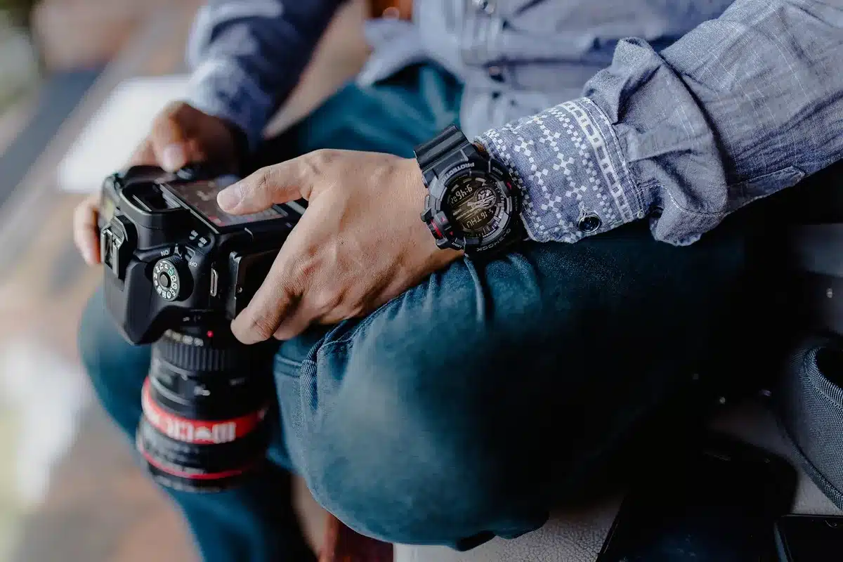 Fotografin mit analoger Kamera auf einer Straße, anonym und seitlich gezeigt